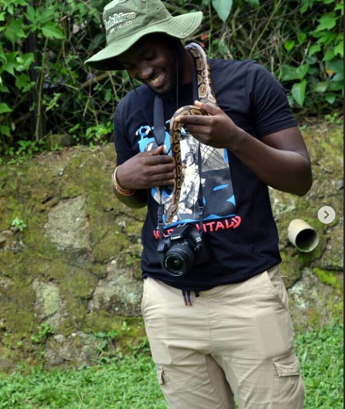 Traveler holding a non-venomous snake during a guided session