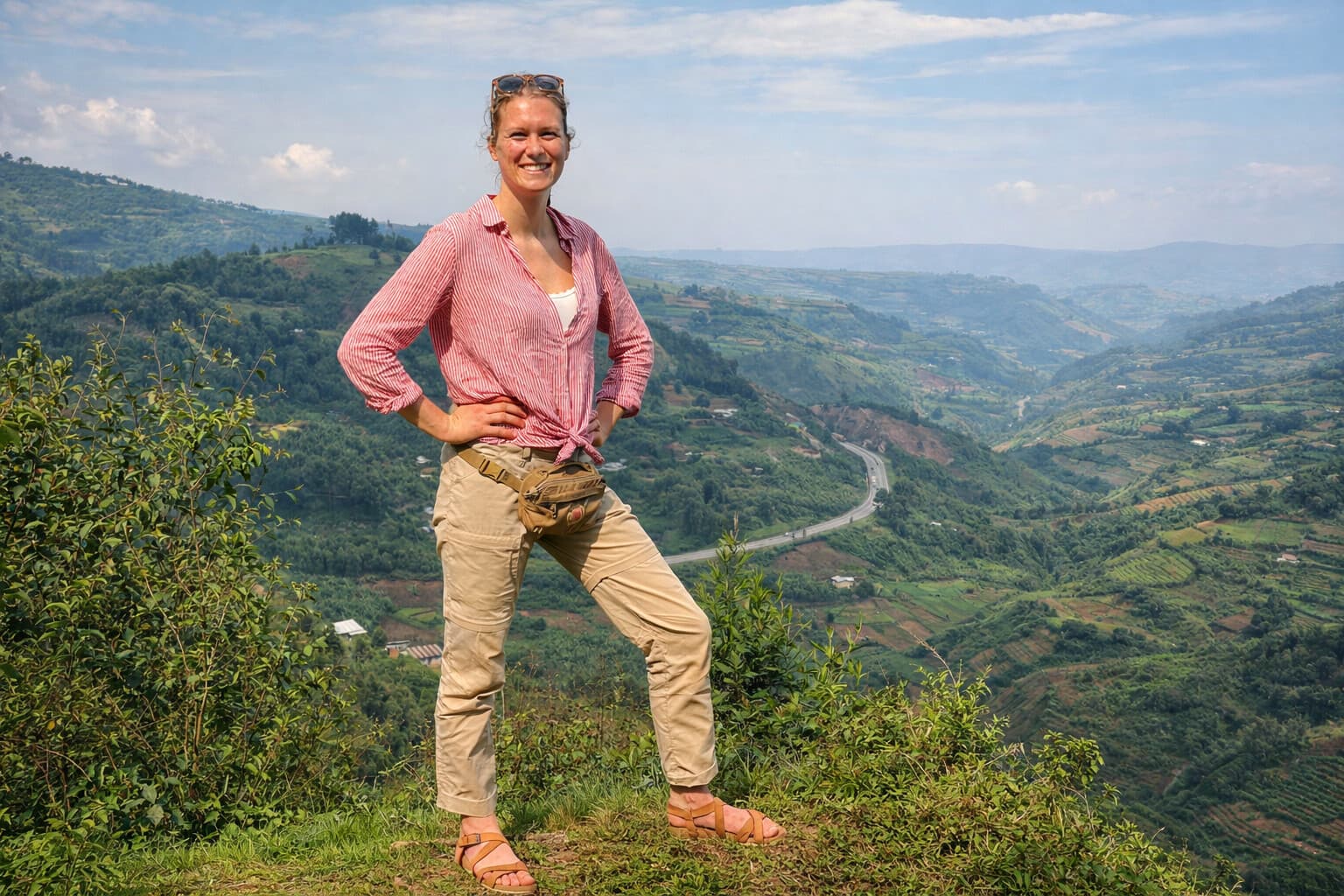 Image of a happy tourist lady taken at the top of a trail up a mountain in Uganda